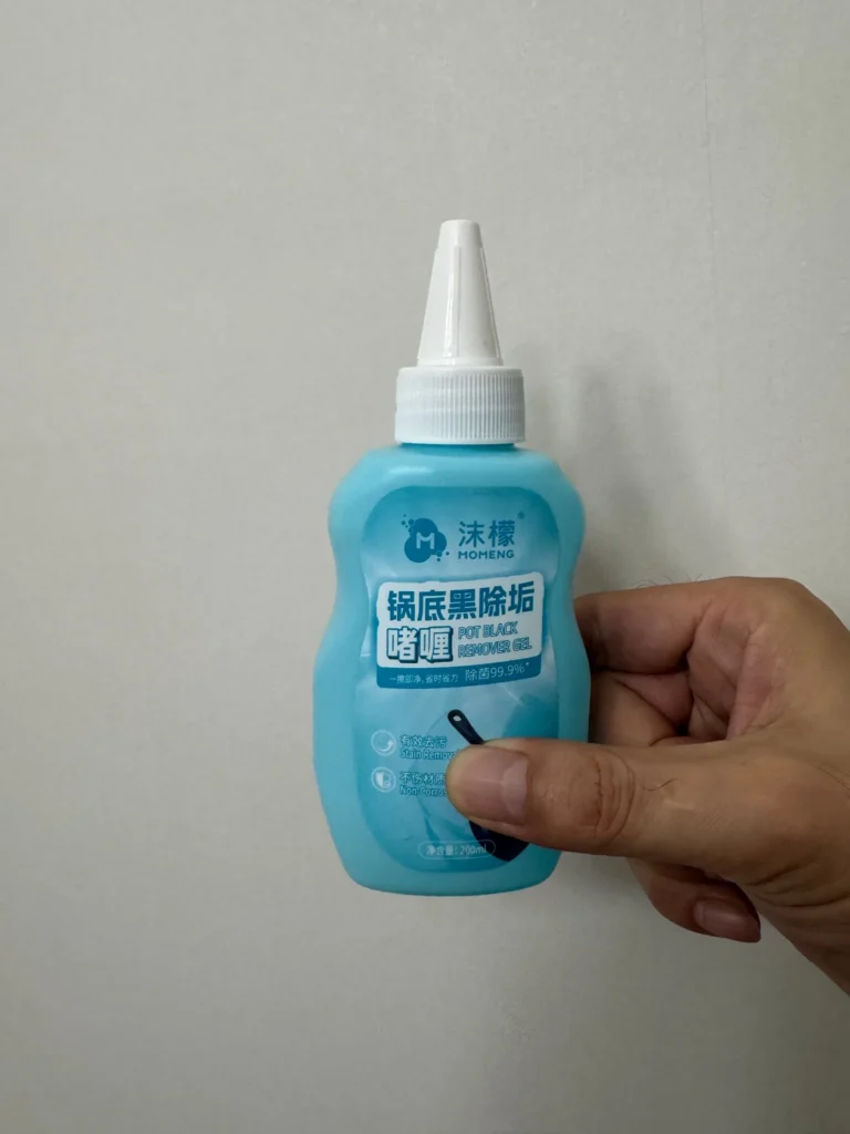 Hand holding MOHENG pot bottom cleaner gel