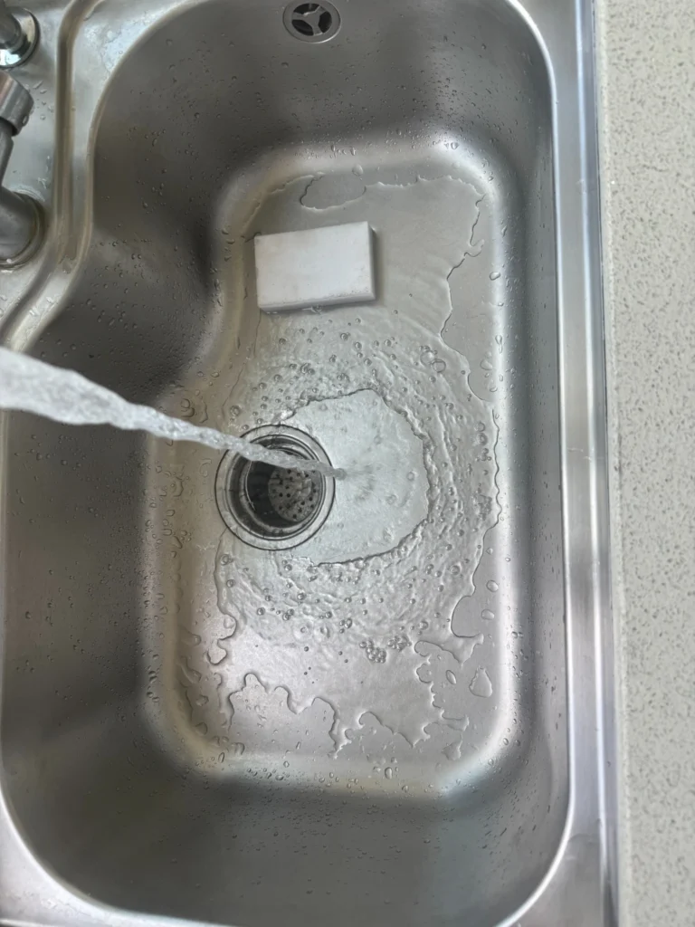 Rinsing a stainless steel sink thoroughly after cleaning