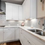 Bright kitchen with a stainless steel sink and white cabinetry
