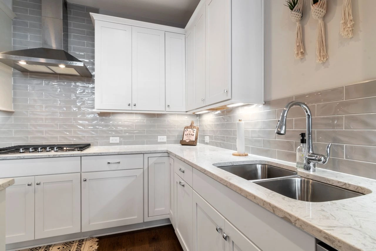 Bright kitchen with a stainless steel sink and white cabinetry