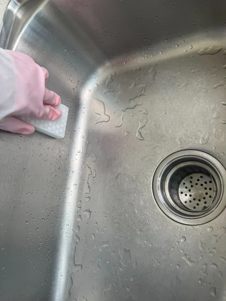 Wiping a stainless steel sink along the grain