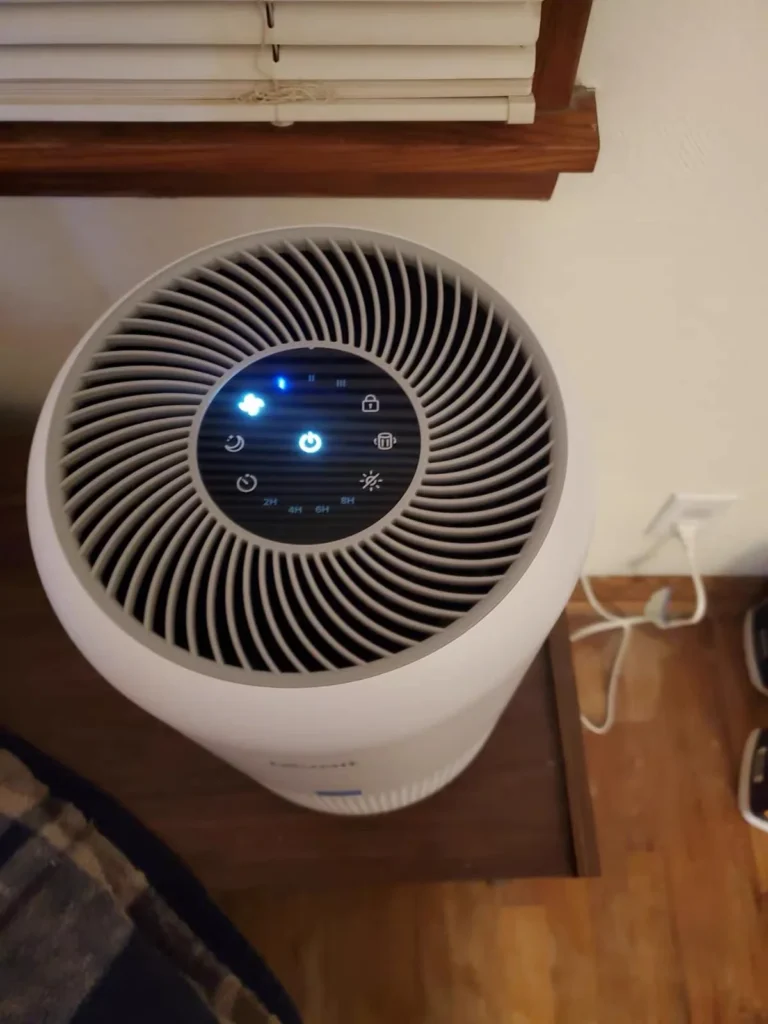 Top controls and air outlet of a white home air purifier