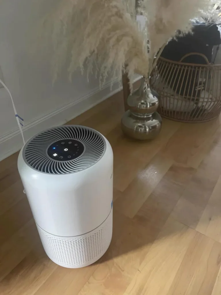 White air purifier running on a wood floor in a real home
