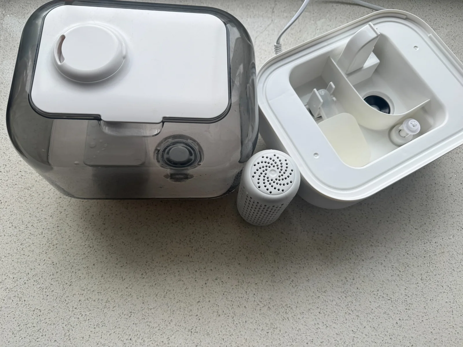 Disassembled humidifier with water tank, base, and filter ready for cleaning