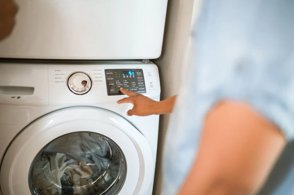 Person using a washing machine in a compact laundry space