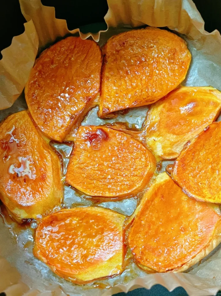 Caramelized sweet potato slices arranged on parchment paper.